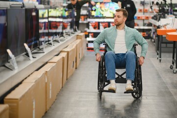 Man navigating electronics store in wheelchair