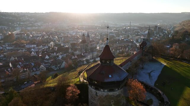 Medieval Esslingen Castle tower emerges in this golden hour drone orbit capturing fortress architecture above city and river integration, Stuttgart region Baden-W&uuml;rttemberg, Germany Esslingen am Necka