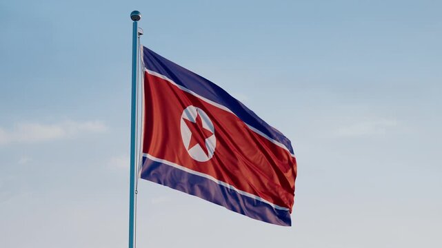 North Korea, Pyongyang: Cinematic Waving National Flag Against Blue Sky