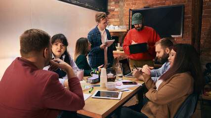 Team discussion around table in modern startup office. Concept of creative collaboration, open...