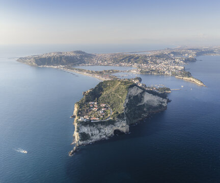 Aerial view of a dramatic coastal landscape where the rugged cliffs of Islet meet the tranquil turquoise sea, a serene vista of natural beauty, Capo Miseno, Bacoli, Campania, Italy.