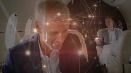 Animation of network of connections over caucasian businessmen on plane - Powered by Adobe