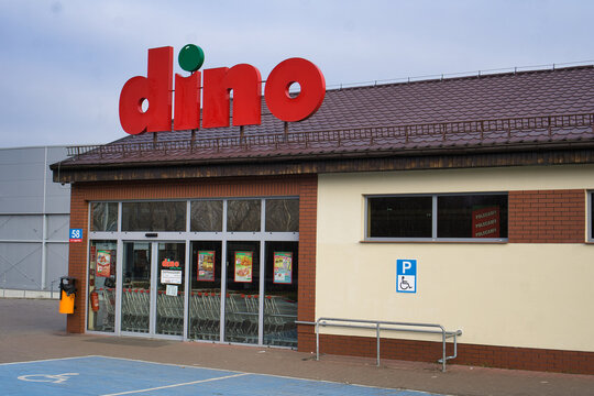 Supermarket Dino &ndash; wejście do polskiego sklepu spożywczego z dużym czerwonym logo na dachu: Rzeszotary, Legnica, Dolny Śląsk, Polska - 25 grudnia 2025 r.