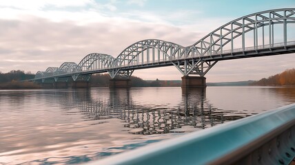 Fototapeta premium A grand steel truss bridge gracefully spans across a wide river under a beautiful pastel sky at dusk