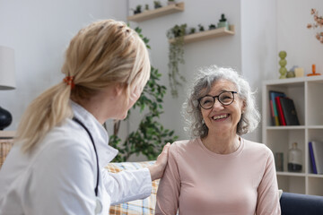 Doctor visiting senior woman at home providing healthcare and support