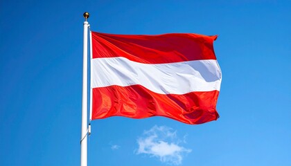 Austria national flag flying on pole against bright blue sky with wispy white clouds