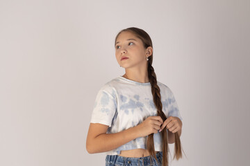 Young girl looking up with a thoughtful expression on a white background