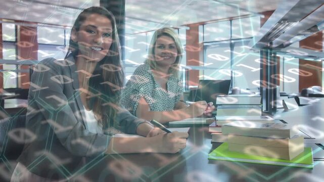 Animation of binary code over smiling caucasian coworkers working in library