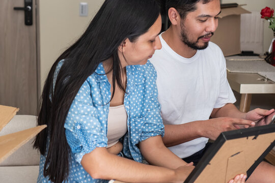 Couple unpacking boxes and reminiscing about achievements together