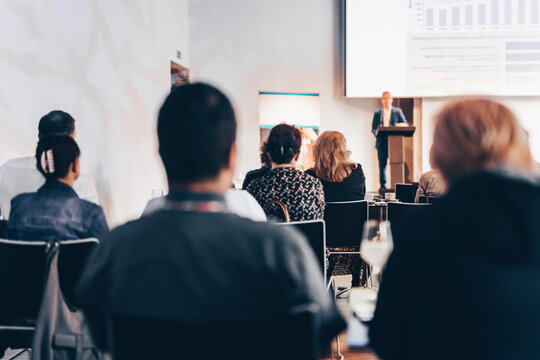 Speaker giving a talk in conference hall at business event. Rear view of unrecognizable people in audience at the conference hall. Business and entrepreneurship concept