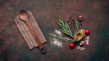 Culinary dark background with wooden spoon and various spices and herbs, top view, flat lay.