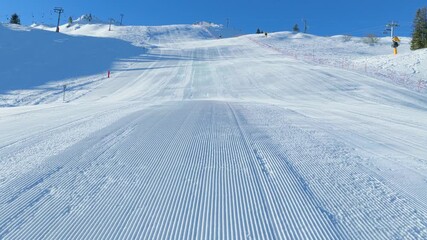 Drone tracking along groomed ski slope designed for giant slalom competitions, offering clean winter sports visuals suitable for professional event promotion