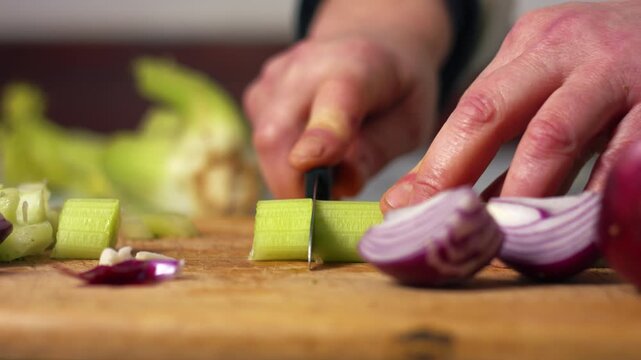 Hand chopping celery with onions