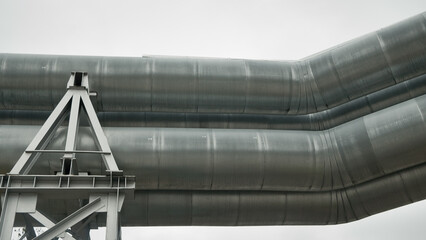 Naklejka premium close-up of a pipeline against a gray sky