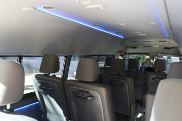 Interior of modern passenger van with comfortable grey leather seat and blue luxury light on ceiling for travel transport and vip shuttle service © CoreRock