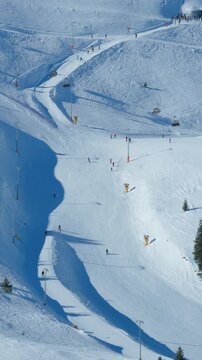 Aerial detail of ski resort slopes showing groomed terrain and lift infrastructure, suitable for winter sports and alpine resort visuals