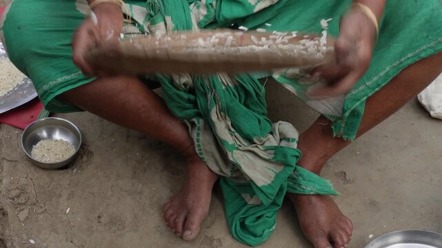 Women winnowing puffed rice with traditional bamboo tray outdoors