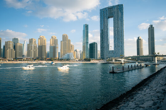 Dubai Marina skyline with Address Beach Resort JBR and boats in the foreground at sunset