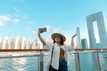 young woman on the beach taking selfie with Dubai Marina skyline at sunset, luxury travel and lifestyle 4k photo