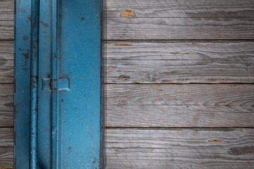 Top-down view of a closed heavy blue metal toolbox placed on the left side of a rustic gray wooden table
