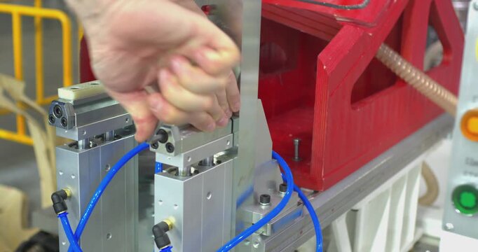 Factory worker adjusting industrial pneumatic machine