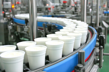 Obraz premium Production line fills small cups on conveyor belt in factory setting Generative AI