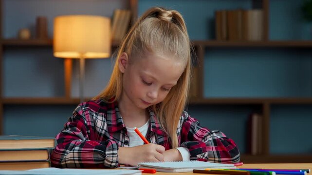 Creative caucasian little girl kid daughter child drawing with color pencils draw picture at evening home pupil sitting at table in children room enjoying art hobby studying create domestic education