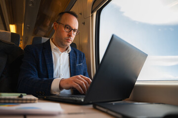 Businessman working on laptop during a train commute