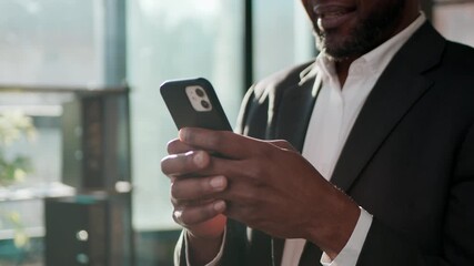 Smiling mature African American businessman texting phone using mobile app business man message smartphone 40s ethnic professional specialist worker in corporate office browsing technology cellphone - Powered by Adobe