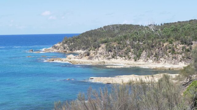 Slow motion landscape of ocean bay beaches with hiking trails along rocky headland coastline covered in bushland trees and vegetation at Rosedale South Coast NSW Australia nature travel and tourism