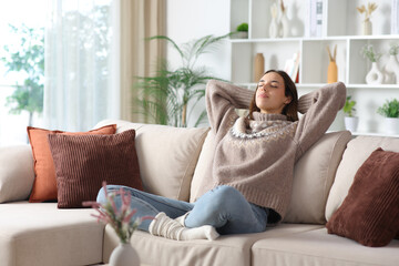 Relaxed female in winter resting sitting on a sofa