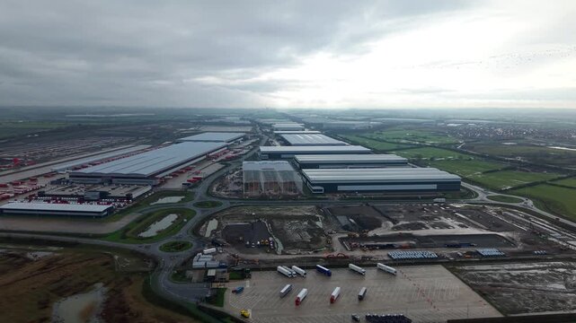 Cinematic bird's eye perspective of a major industrial transport hub in Crick England with warehouses and rail freight links for UK import and export.