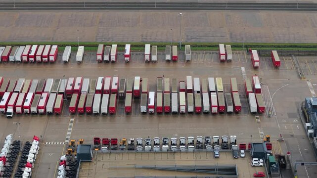 Aerial drone close up of heavy goods vehicles and trailers parked in loading bays at a major distribution centre near Crick Northamptonshire UK day.
