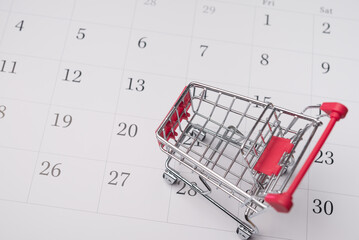 Shopping trolley on blank white calendar background copy space. Shopping schedule and preparation for discount promotion online e-commerce or sale offline, commerce business and so on concept.