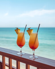 Tropical cocktails in glasses placed on a wooden railing under a blue sky