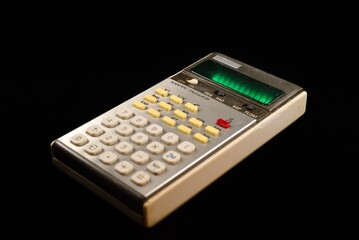 Angled side view of vintage scientific calculator on black background