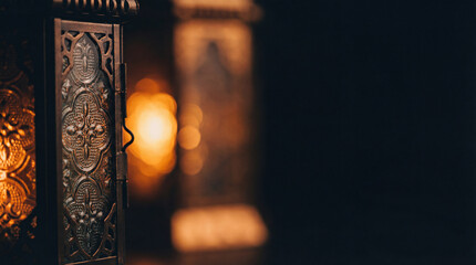 Ornate lantern glows in dark room. Lantern light with warm bokeh, lantern decor for Ramadan Kareem, Eid Mubarak invite, iftar night, arabic style, deep copy space, cozy night concept