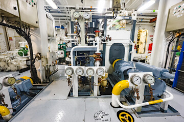 Marine pump system with electric motors, pressure gauges, valves and pipelines inside ship engine room, industrial ship machinery. © Сергей Жмурчак