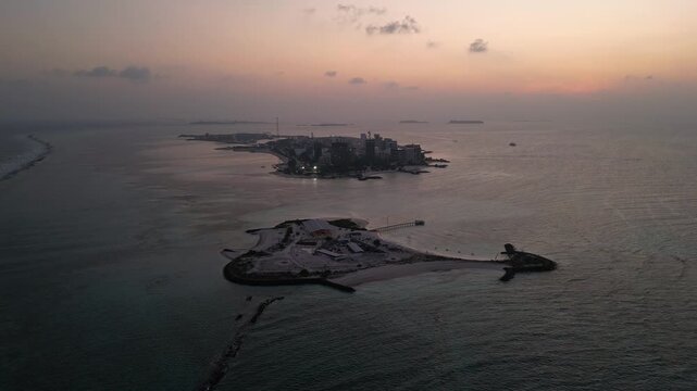 Maafushi, Maldives: Aerial drone footage of dramatic sunset over small island and Maafushi, islands in Kaafu Atoll of Maldives. 