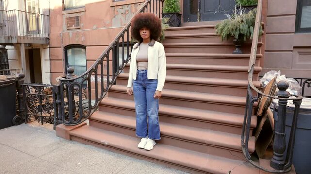 Fashionable african american woman walking down stoop stairs in new york city