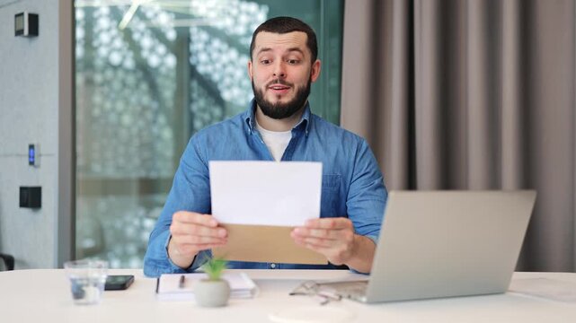 Man opens document, expresses initial surprise, then pure joy and excitement. Celebration follows receiving wonderful news, indicating success or positive achievement in environment.