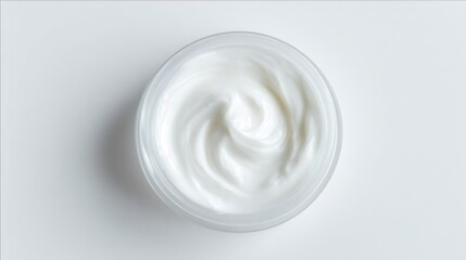 White cosmetic cream swirled in a clear jar. Skincare product with gentle texture. Beauty and body care concept. Health and wellness.
