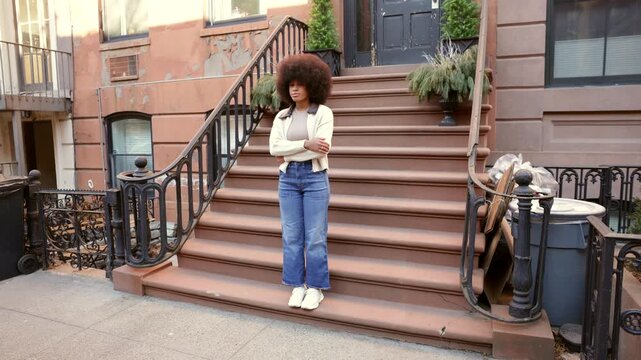 Confident african american woman smiling on new york city stoop