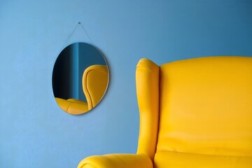 Modern Yellow Armchair and Round Mirror on Blue Wall - Minimalist Interior Design