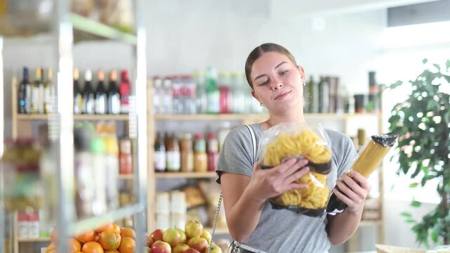 Woman choosing pasta and spaghetti in the supermarket. European woman buying durum wheat pasta in the grocery section. High quality 4k footage