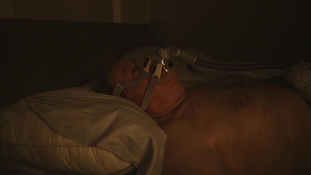 CPAP wearer looks up and is fully awake in the middle of the night after discomfort with air flow