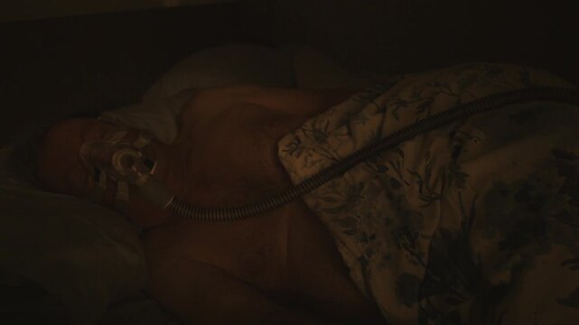 adult senior male sleeping well with the help of a CPAP machine at night