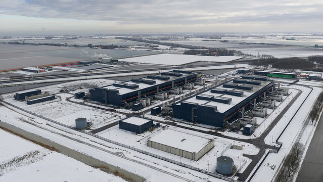 Aerial view of large, modern buildings contrasting against the stark white snow-covered landscape, Datacenter, Noord-Holland, Netherlands.