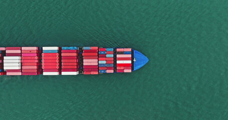 Cargo ship navigating through the open ocean, freight containers stacked on deck, illustrating global logistics, international trade, and marine transportation from a top down aerial perspective