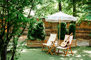 Guitar on striped chair in sunny garden for music and leisure
